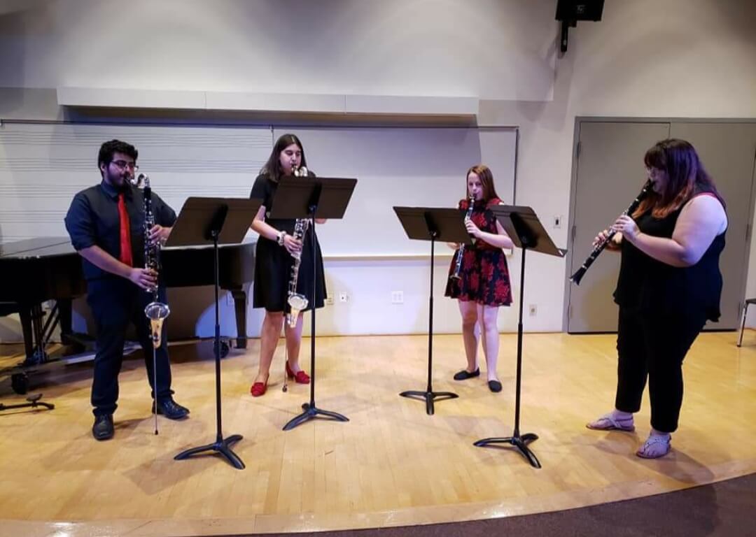 Clarinet quartet playing on a practice stage