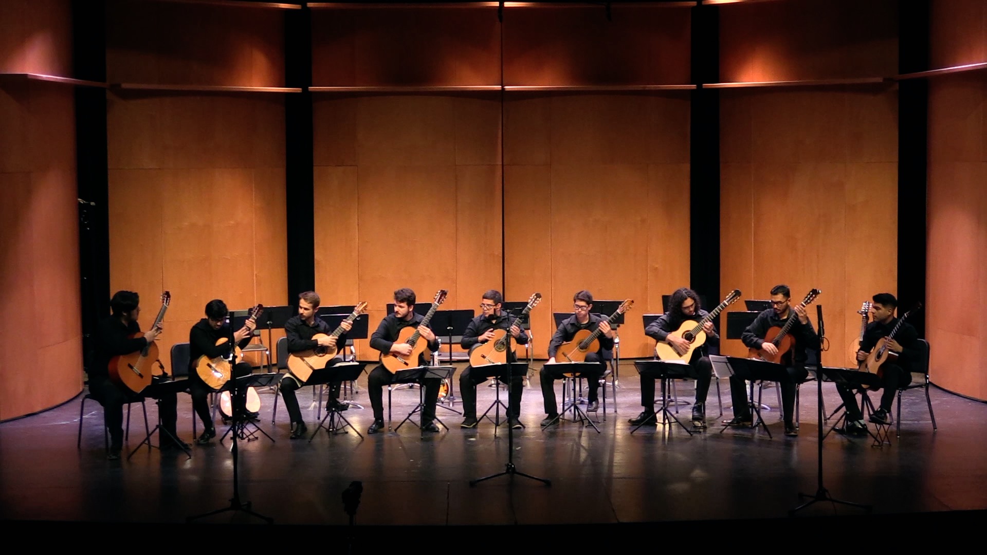 Nine Guitar students playing on a concert stage