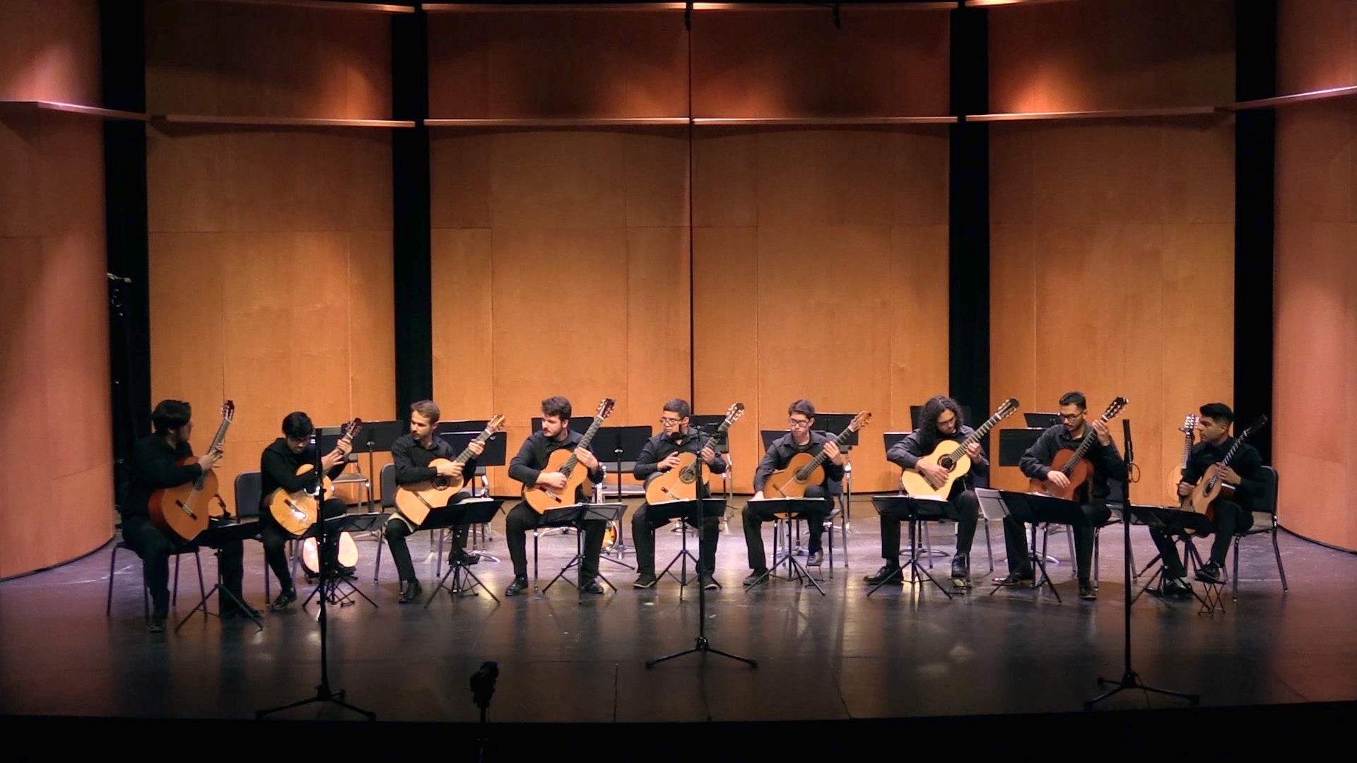 Nine Guitar students playing on a concert stage