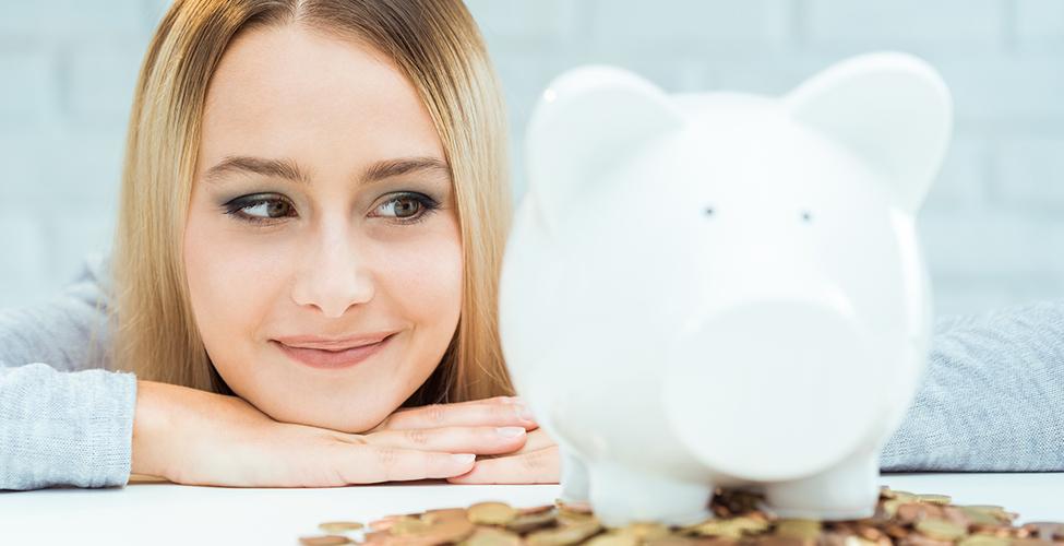 Woman with a piggy bank standing on coins
