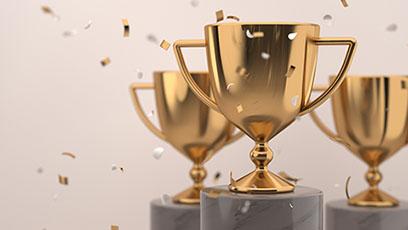 Three gold trophies with falling gold confetti