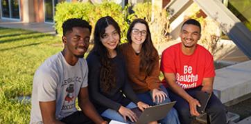 Students sitting outside the Business building on the main campus