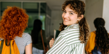 Smiling female student walking to class.