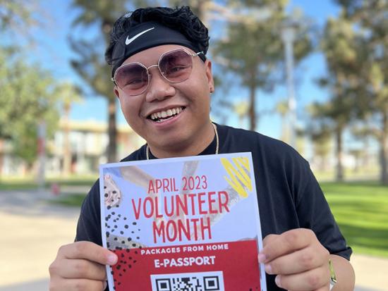 Student holding a Volunteer Month E-passport