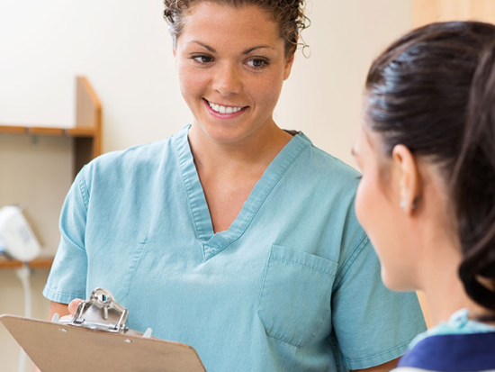 A medical assistant helping a patient.