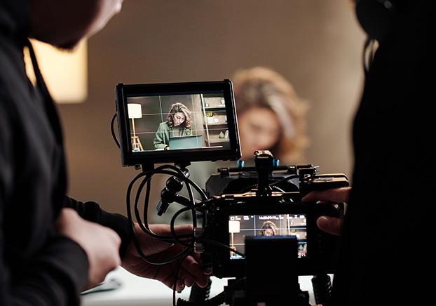 A picture of two video camera operators filming an actor.