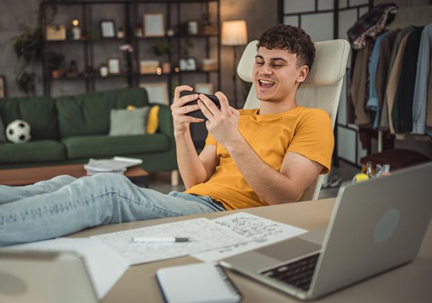 Laughing male student on the phone.