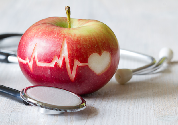 Heartbeat line on red apple and stethoscope.