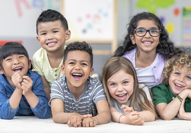 Young children facing the camera and smiling.