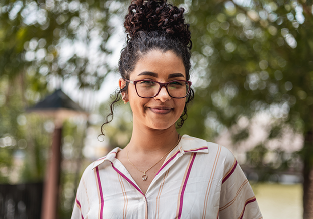 Smiling female student wearing glasses and smiling at the camera.